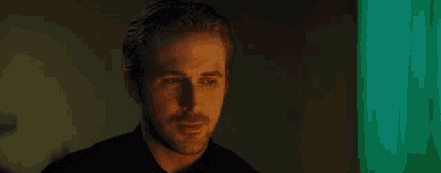 a close up of a man 's face with his eyes closed in a dark room