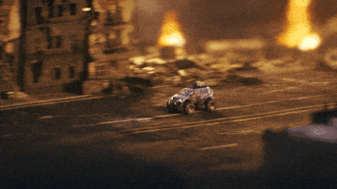 a toy car is driving down a destroyed city street