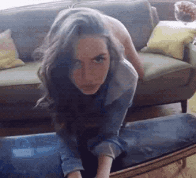 a woman crawling on a table in front of a couch