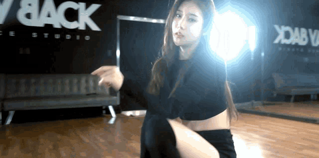 a woman is dancing in front of a sign that says " black "
