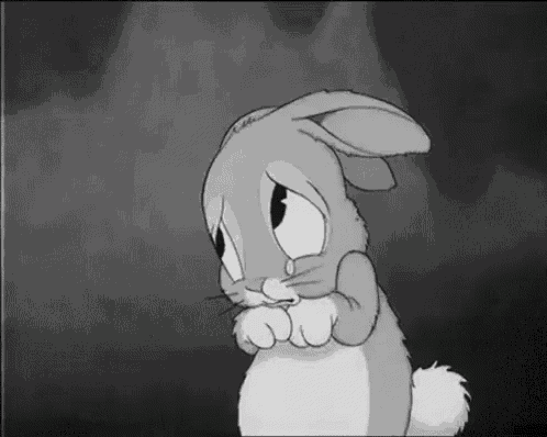 a black and white cartoon rabbit with a sad look on its face .