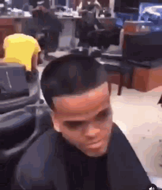 a man is sitting in a chair in a barber shop .
