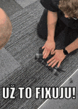 a man is kneeling down holding a camera with the words uz to fixuju written on the bottom
