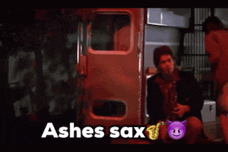 a man playing a saxophone next to a sign that says ' ashes sax '