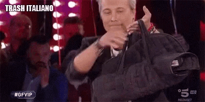 a man is holding a black bag in his hands and making a funny face .