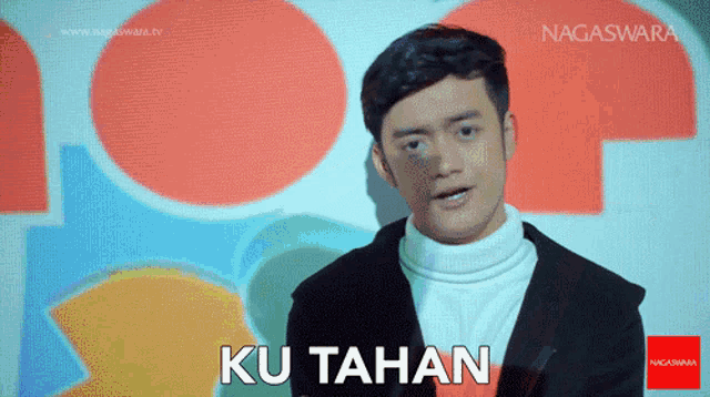 a man in a suit says ku tahan in front of a colorful background
