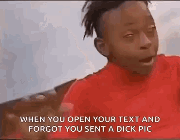 a man in a red shirt is making a funny face while looking at the camera .