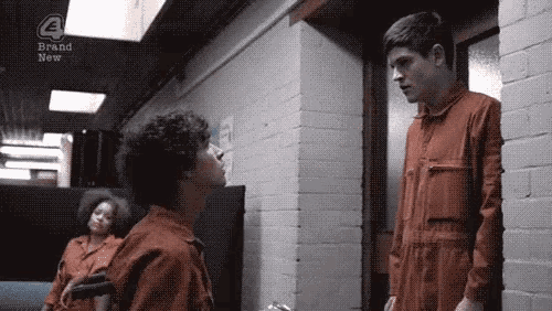 a man and a woman are standing next to each other in a hallway in a prison cell .