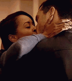 a man and a woman are kissing each other in a room .