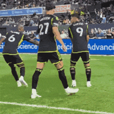 soccer players on a field with one wearing the number 27