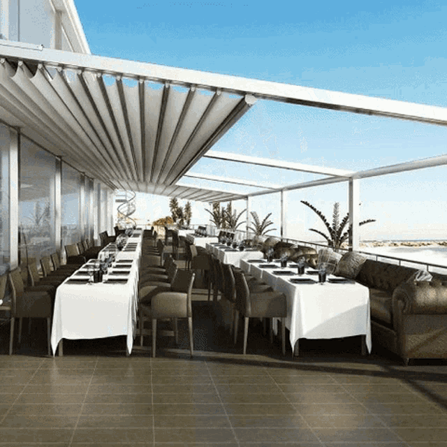 a large outdoor dining area with tables and chairs under a canopy