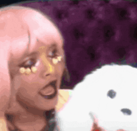 a woman in a pink wig is holding a white stuffed animal