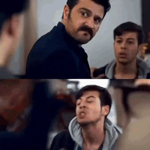 a man with a mustache is making a funny face while talking to two other men .