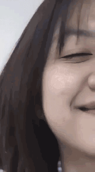 a close up of a woman 's face with a smile on her face