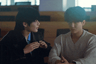 two young men sitting next to each other in a classroom
