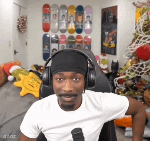 a man wearing headphones is sitting in a chair in front of a christmas tree