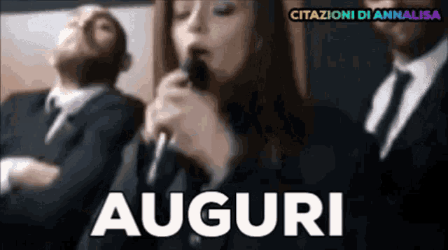 a woman singing into a microphone with the word auguri in the corner