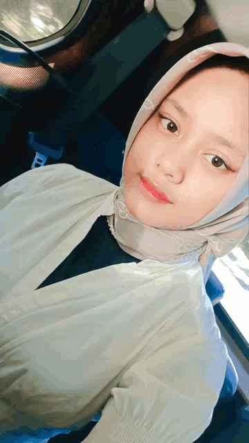 a young girl wearing a hijab and a white shirt