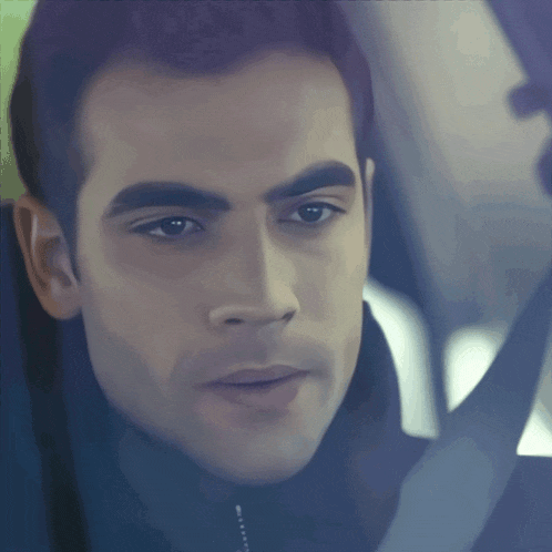 a close up of a man 's face with a black jacket