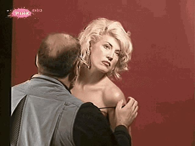 a man is taking a picture of a woman 's breasts .