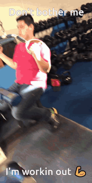 a man in a pink shirt is working out in a gym with the words " don 't bother me "
