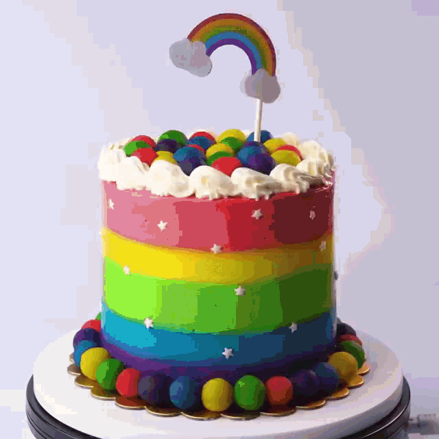 a rainbow cake with a rainbow topper on top of it