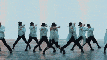 a group of people wearing hats and white shirts are dancing together