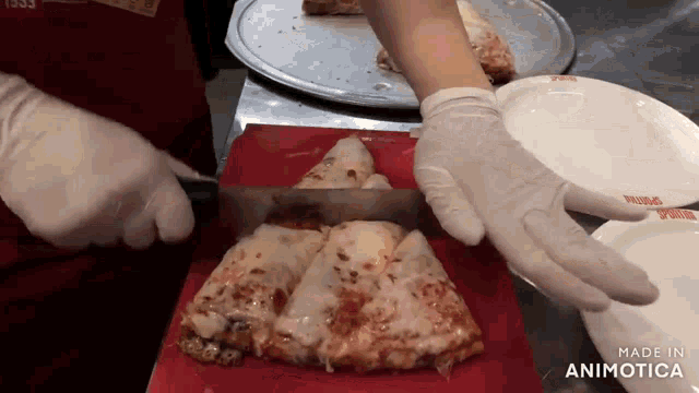 a person is cutting a slice of pizza with a knife on a red cutting board that says made in animatica