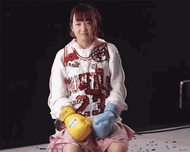 a girl wearing boxing gloves and a vest that says ' tokyo '