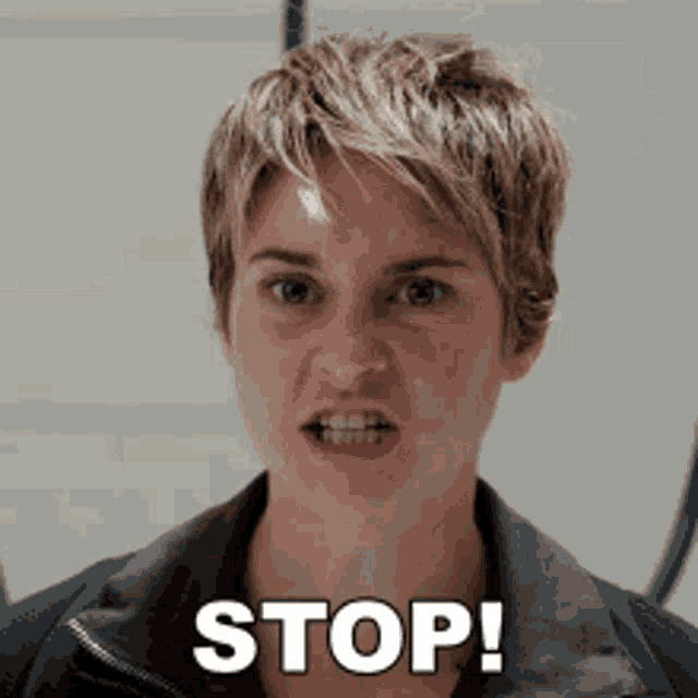 a woman with short hair is making a funny face and says stop !