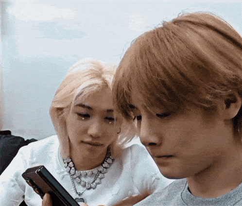 a man and a woman are looking at a phone together