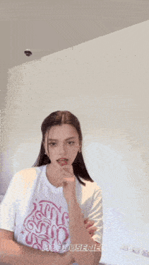a woman wearing a white t-shirt that says hooduserie on it