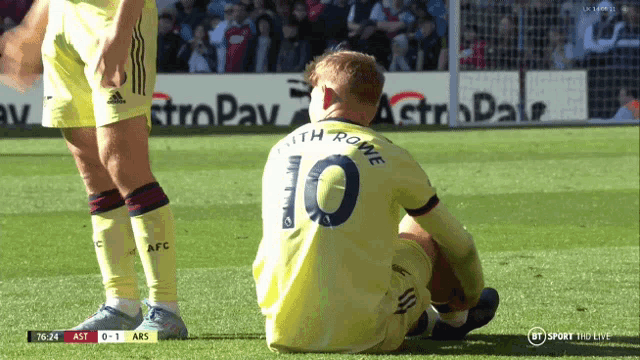 a soccer player with the number 10 on his jersey sits on the field
