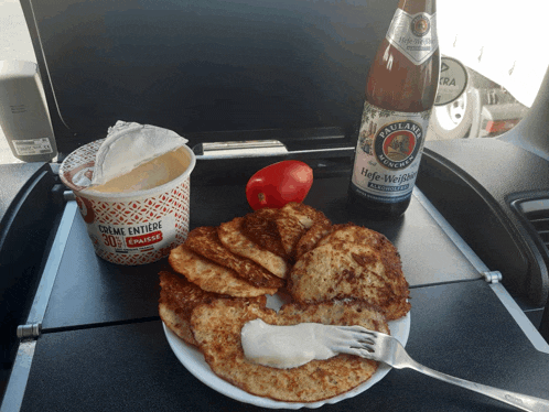 a bottle of paulaner beer sits on a table next to a plate of pancakes