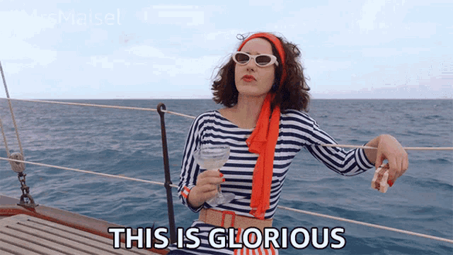 a woman on a boat is holding a glass of wine and says " this is glorious "