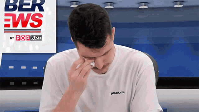 a man wearing a patagonia t-shirt is crying