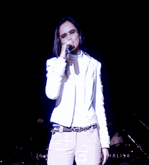 a woman singing into a microphone with the word halisa on the bottom right corner