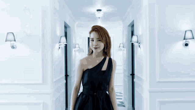 a woman in a black dress walks down a checkered hallway towards a blue door