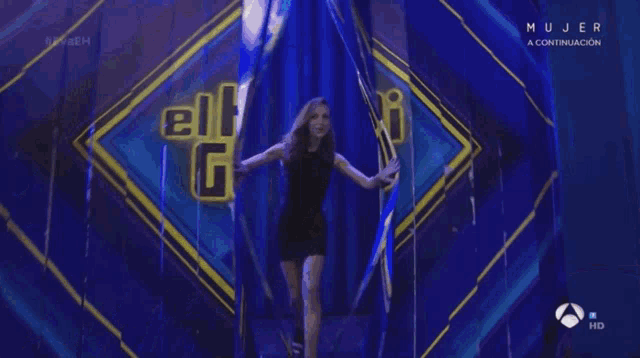 a woman in a black dress is dancing on a stage with #evaeh written on the bottom