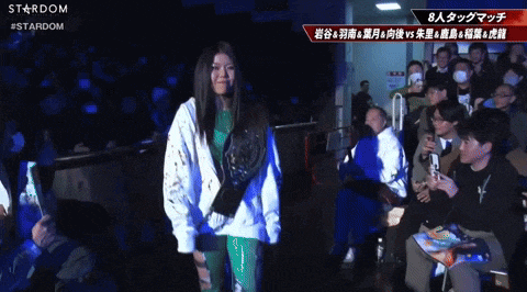 a woman stands in front of a crowd with the word stardom on the bottom right
