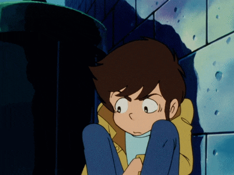 a boy in a yellow jacket sits on the ground in front of a wall