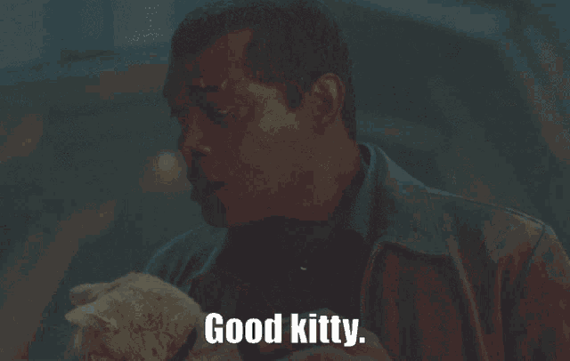 a man holding a stuffed animal with the words good kitty written below him
