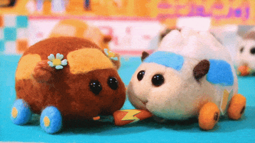 a stuffed animal with a flower on its head is eating a carrot from another stuffed animal