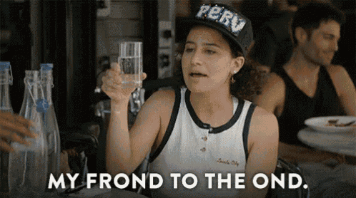 a woman in a peru hat is holding a glass of water and saying `` my front to the ond '' .