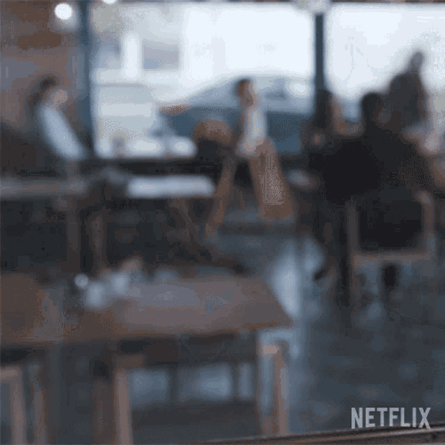 a blurry picture of people sitting at tables in a restaurant with netflix written on the bottom right