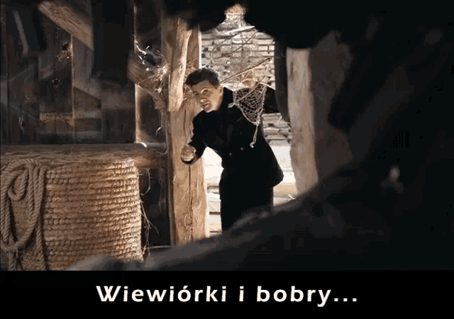 a man in a suit is standing in a dark room with the words wiewiórki i bobby written below him