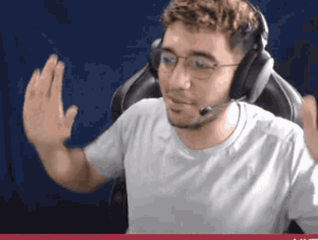 a man wearing headphones and glasses is waving