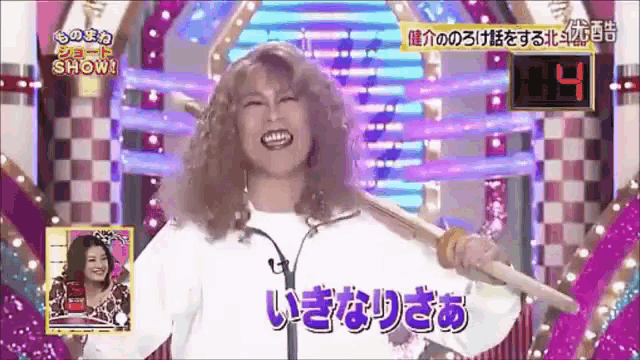 a woman holding a microphone in front of a sign that says ' show ' on it