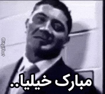 a black and white photo of a man in a suit and tie with arabic writing on it