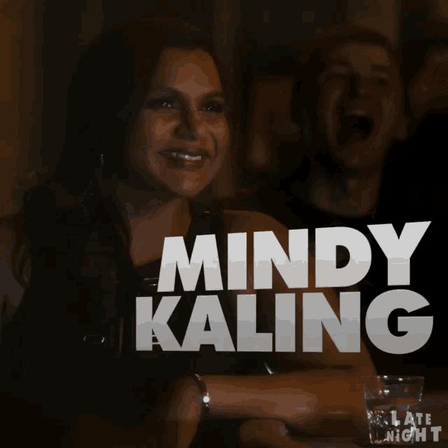 a picture of mindy kaling with a man laughing behind her